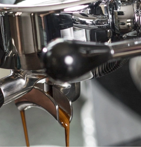 Primo piano di una macchina per l'espresso con caffè che esce.