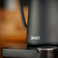 Black kettle with GRAEF logo on a black surface, close-up shot.