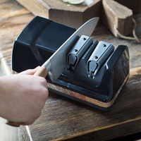 Coltello affilato con un affilatore, primo piano, superficie in legno, Chef's Choice.