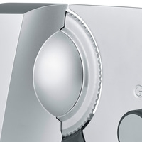 Close-up of a silver kitchen slicer with a serrated blade and a circular design