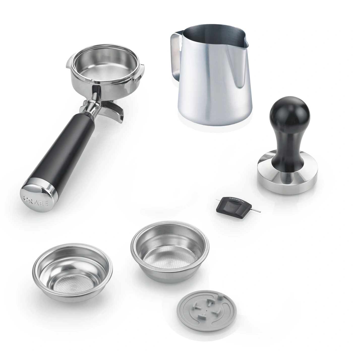 Accessoires pour machine à expresso : porte-filtre, pichet à lait, tamper, paniers, outil de nettoyage et porte-capsule.