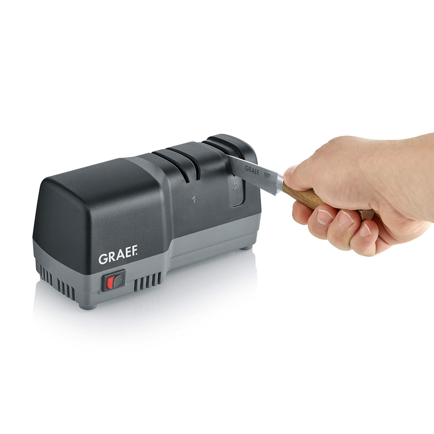 Graef knife sharpener with knife and hand, ready to sharpen the blade.