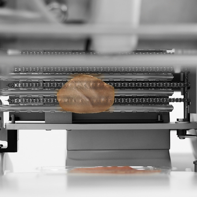 Macchina con fetta di carne. Produzione, industria alimentare, tecnologia, primo piano.