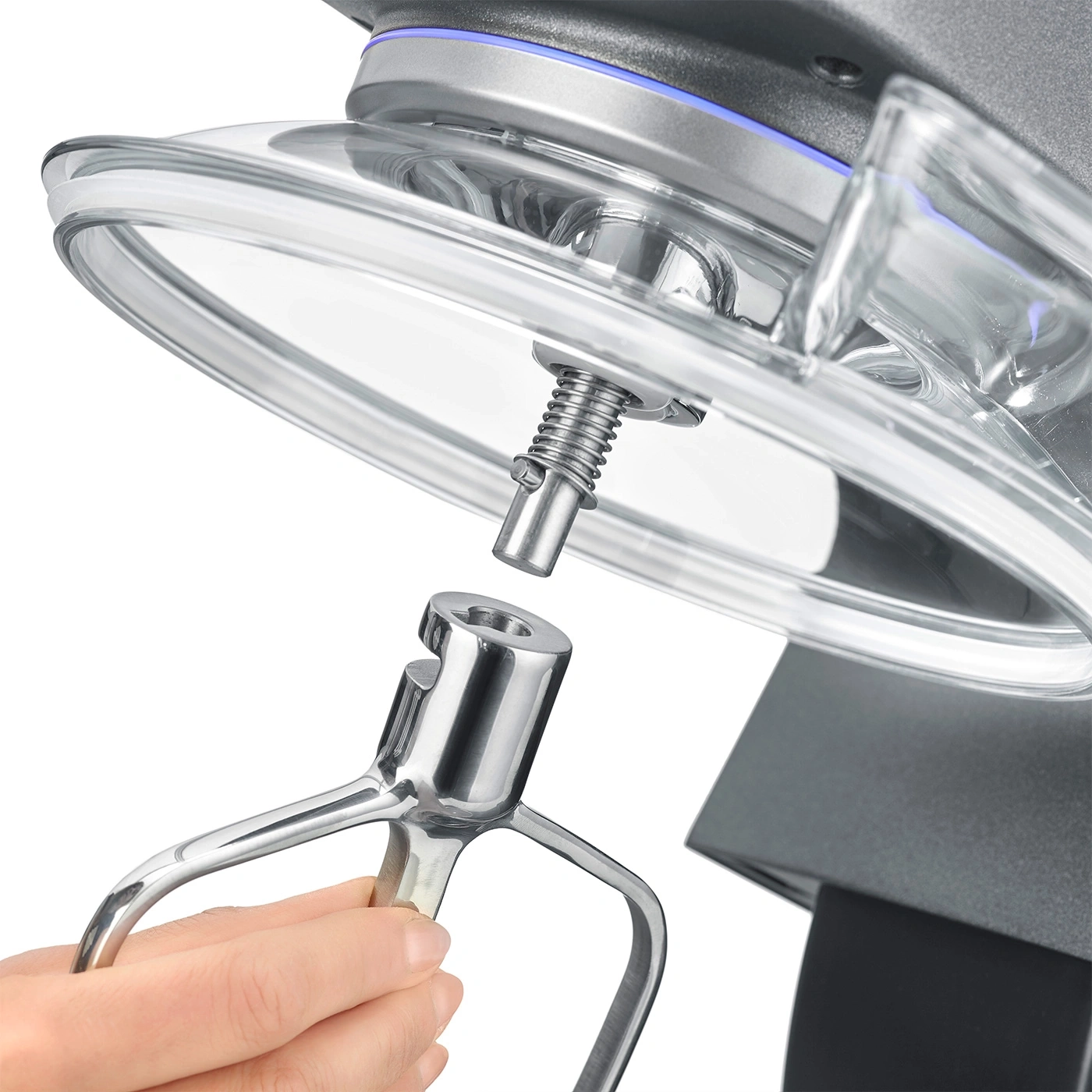 Primo piano di un mixer con accessorio in fase di collegamento, mano che lo tiene.