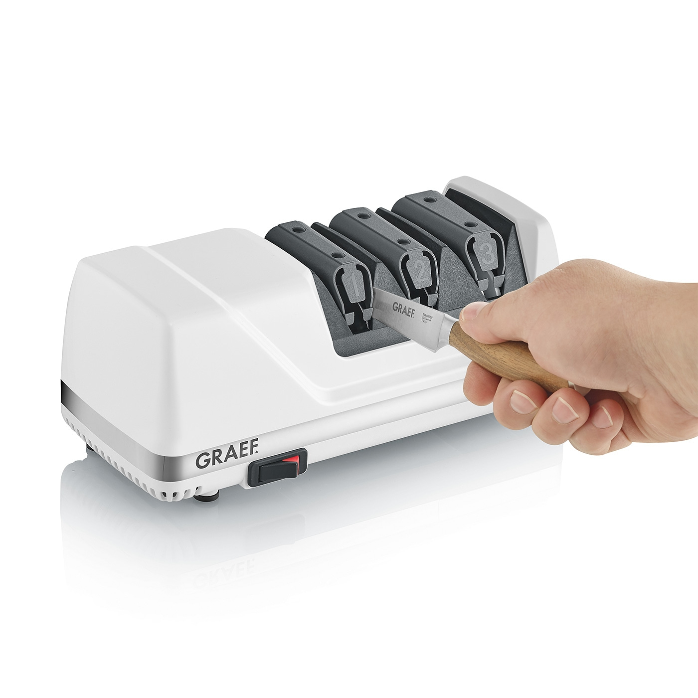 Knife sharpener with knife, white device, GRAEF logo, sharpening slots, hand holding knife