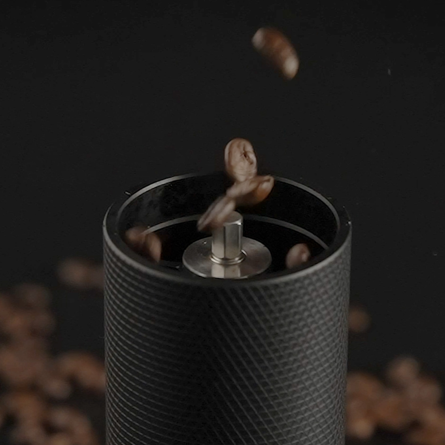 Grains de café tombant dans un moulin à café, gros plan.