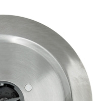 Gros plan d'une plaque métallique argentée avec un trou et une partie noire, surface brillante.