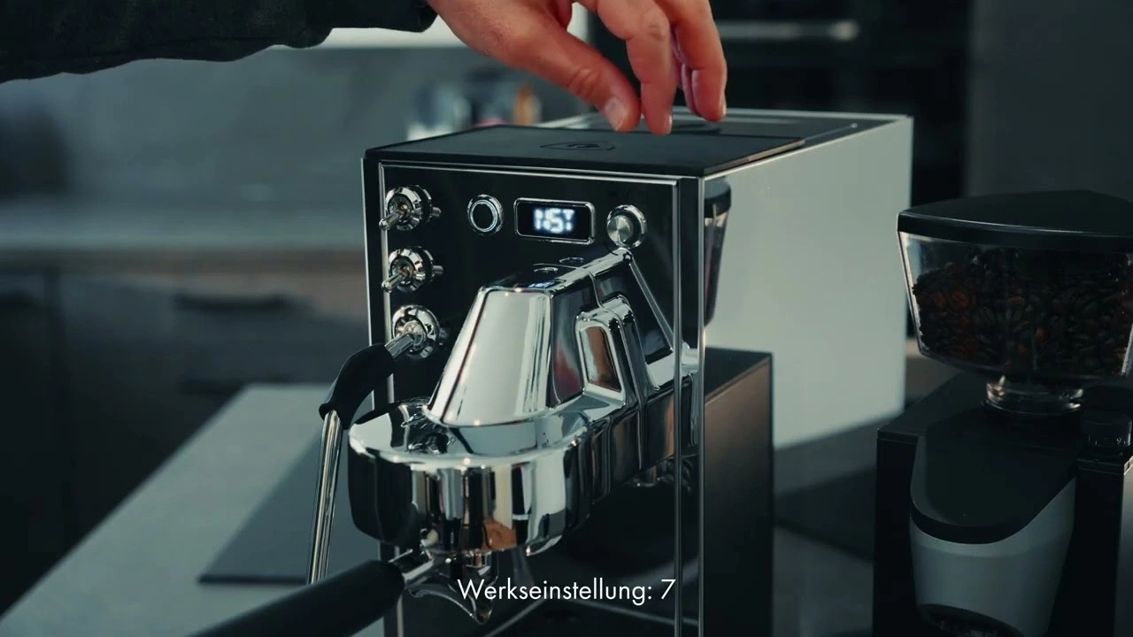 Une personne utilise une machine à expresso avec un moulin.