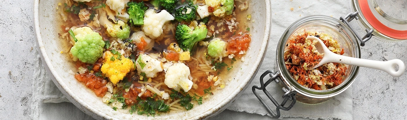 Soupe aux légumes et épices dans un bol et un pot sur une table
