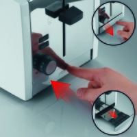 Un grille-pain en fonctionnement, avec le niveau de brunissage réglé et le tiroir à miettes ouvert.