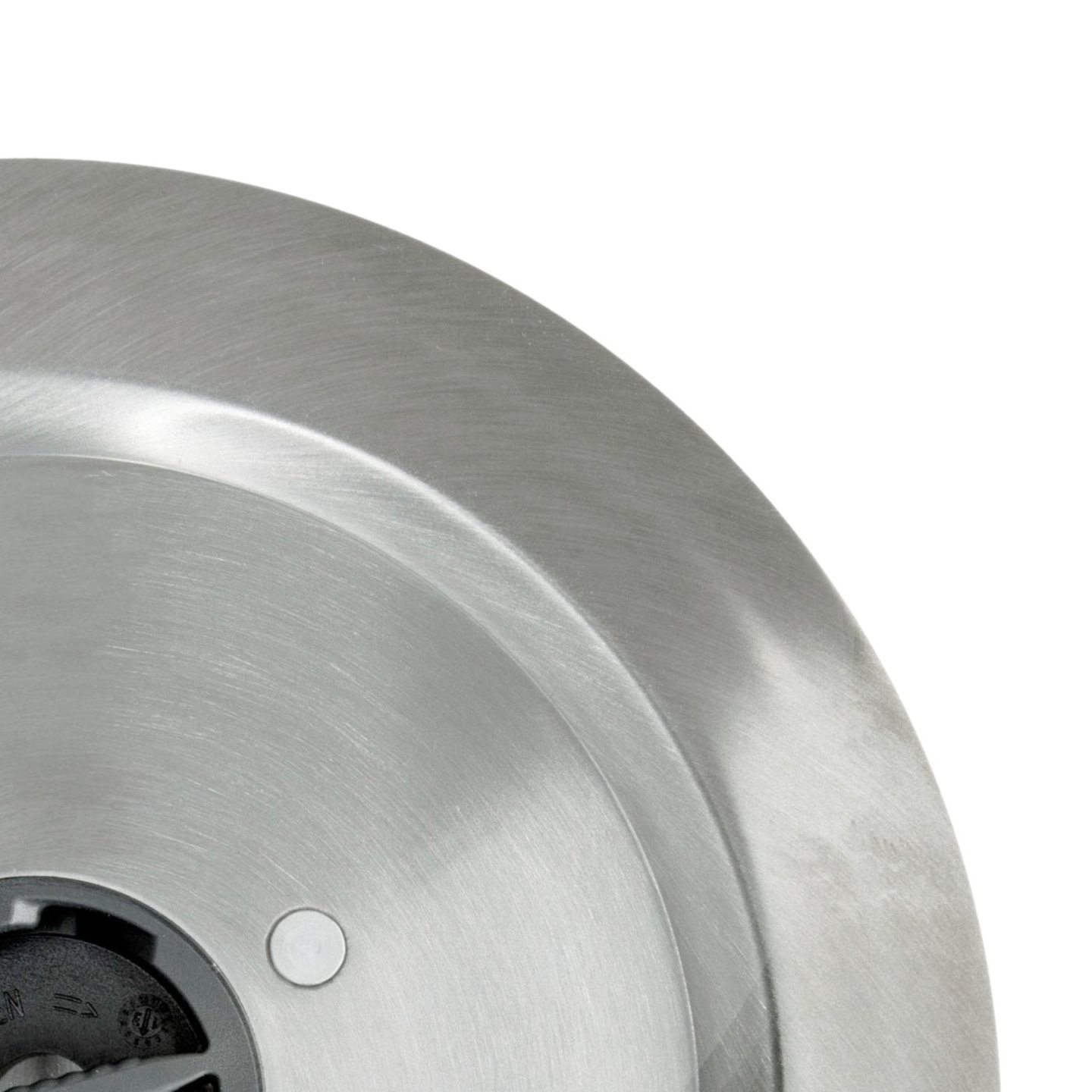 Gros plan d'une plaque métallique argentée avec un trou et une partie noire, surface brillante.