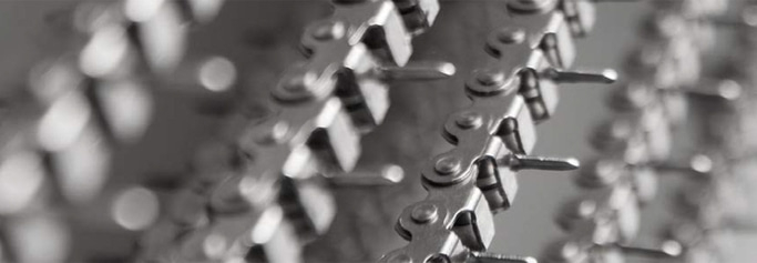 Primo piano di una catena metallica con perni ad incastro, immagine in scala di grigi