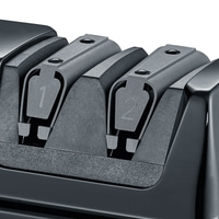 Close-up of a black knife sharpener with two slots labeled 1 and 2.