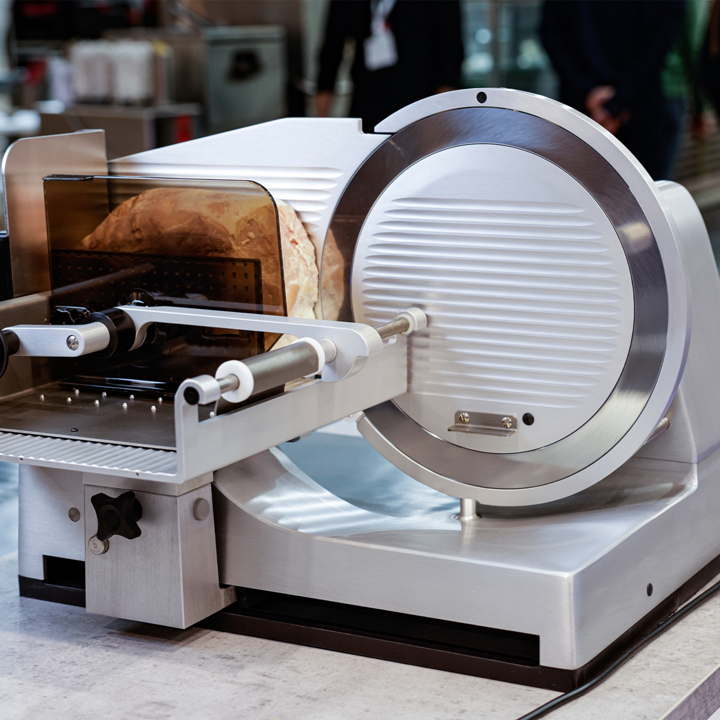 Meat slicer with bread. Stainless steel, professional, kitchen, food preparation.