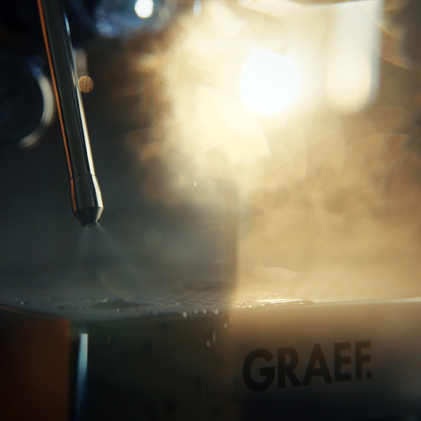 Jet de vapeur frappe une surface avec des gouttelettes d'eau et le logo GRAEF.