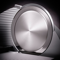 Gros plan d'une trancheuse à viande argentée avec une surface brillante et des détails