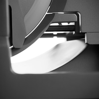 Primo piano astratto di strutture metalliche grigie con luce e ombra.