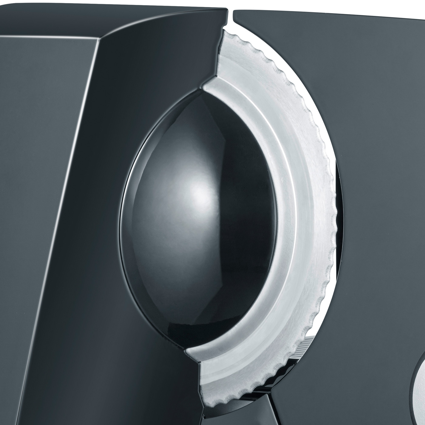 Gros plan d'une trancheuse à viande grise avec une lame dentelée et une surface lisse et réfléchissante.