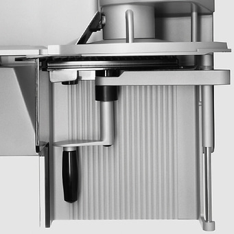 Close-up of a silver meat slicer with handle and blade mechanism