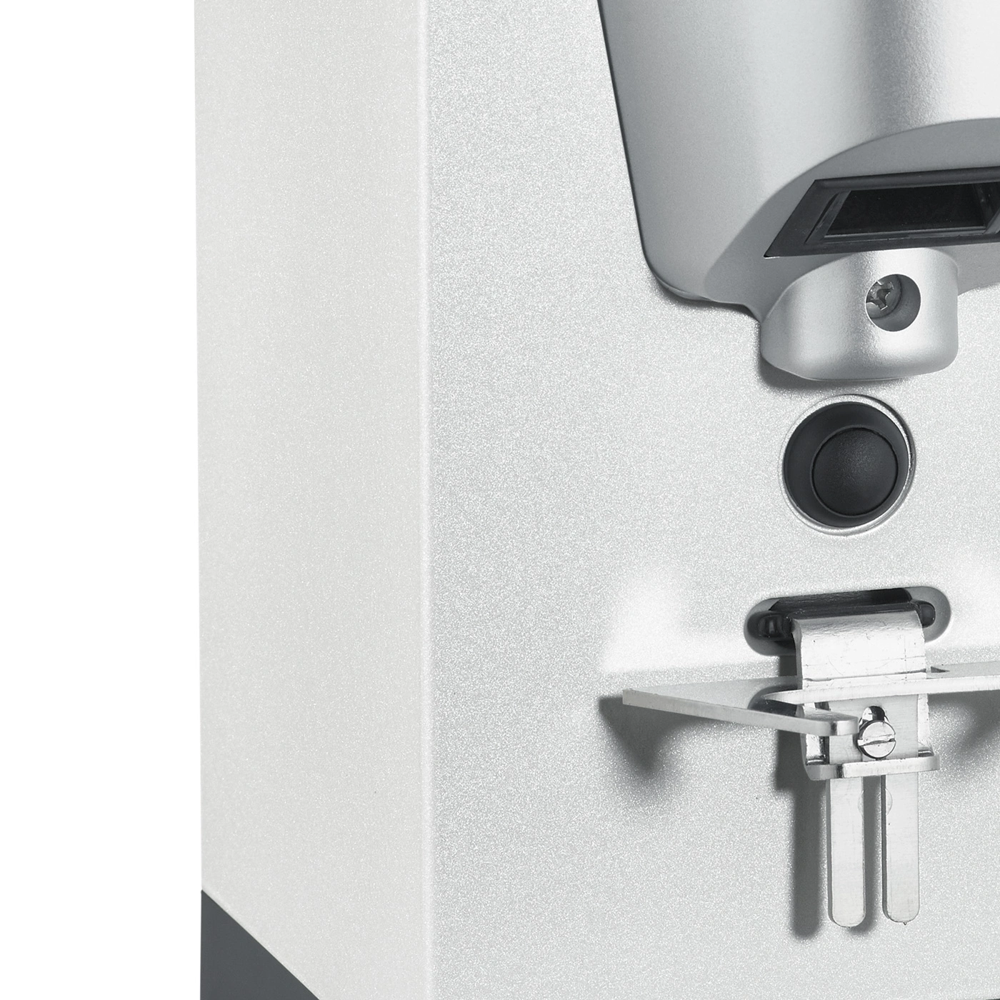 Close-up of a silver appliance with a button and metal components.