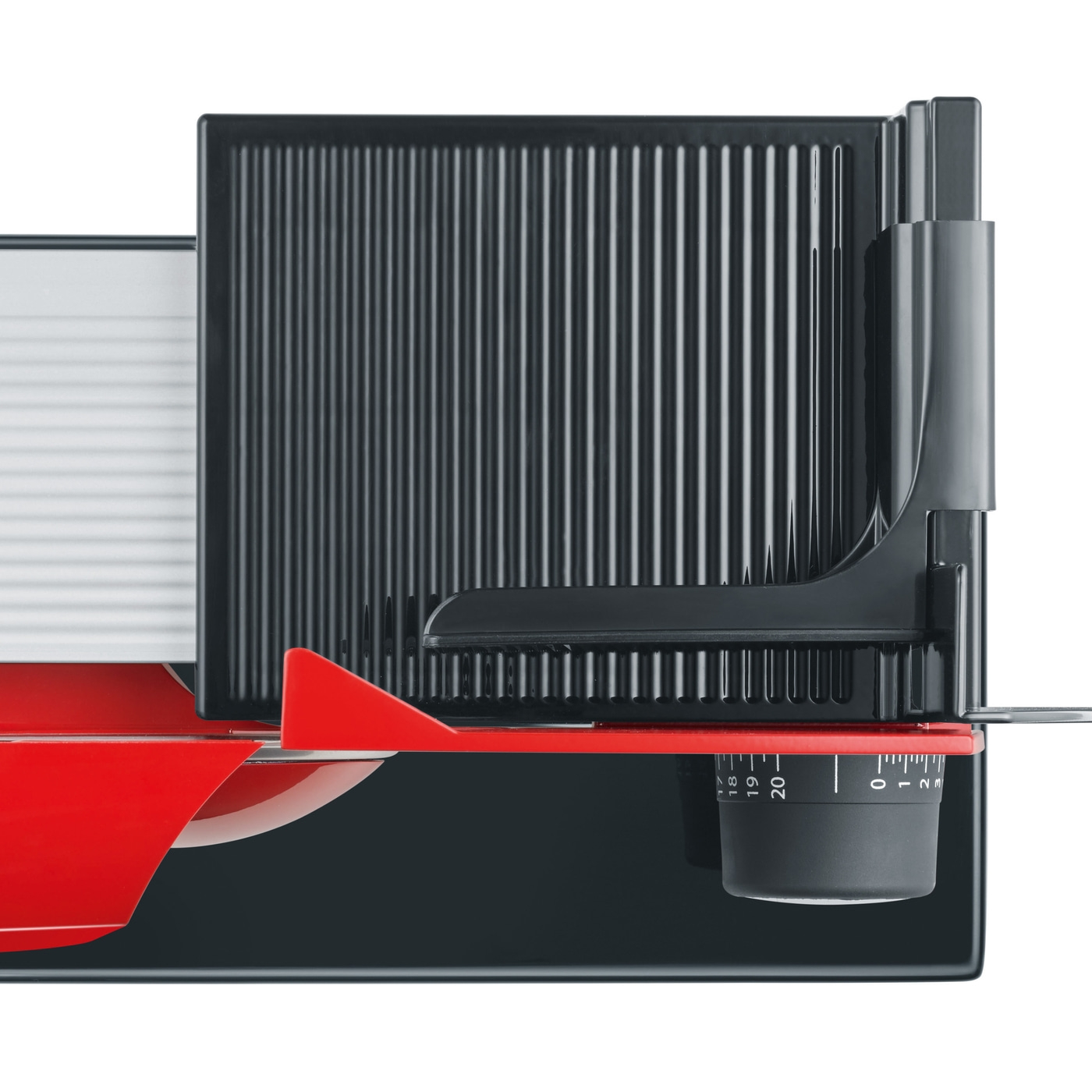 Close-up of a food slicer with red and black parts and a dial.