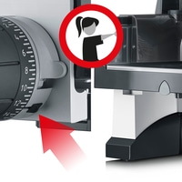 Panneau de sécurité sur une trancheuse avec flèche rouge et symbole femme, danger