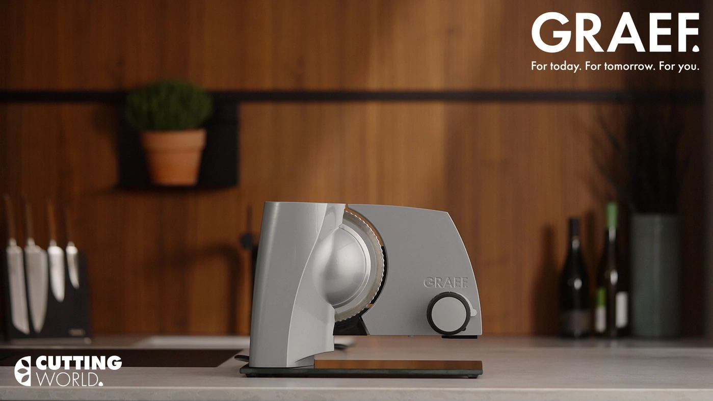 A GRAEF slicer sits on a countertop with a wooden background.