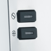 Deux boutons noirs avec des symboles sur une surface blanche, gros plan, commandes d'appareil.