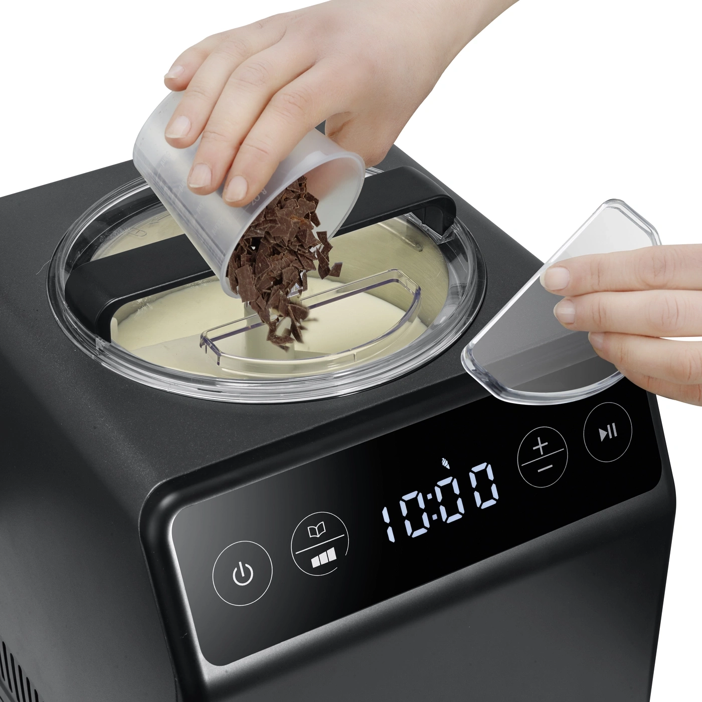 A hand adds chocolate chips to an ice cream maker.