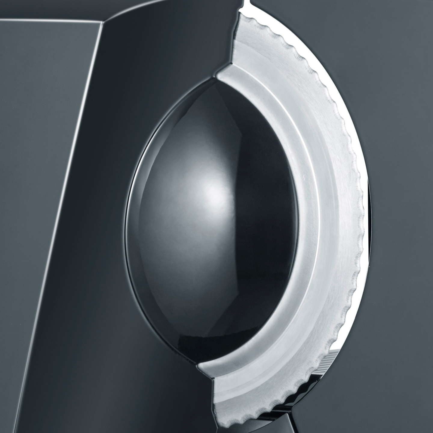 Close-up of a sharp blade and a silver wheel on a dark background.