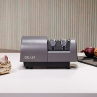 Graef knife sharpener, gray, with onions and garlic on a white table