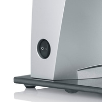 Close-up of a gray appliance with an on/off switch, resting on a dark base.