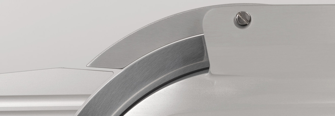 Close-up of a silver knife with a screw and a curved blade