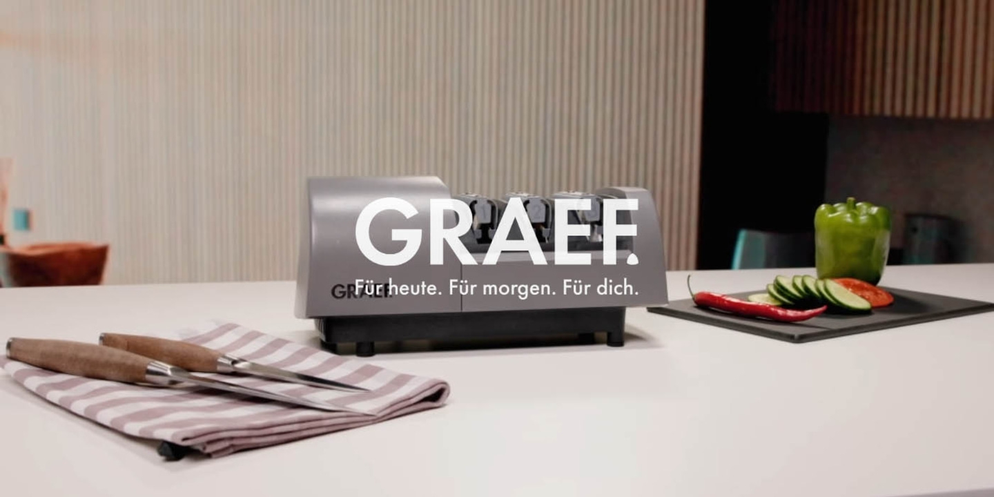 Affilacoltelli Graef con verdure e coltelli su un piano di lavoro