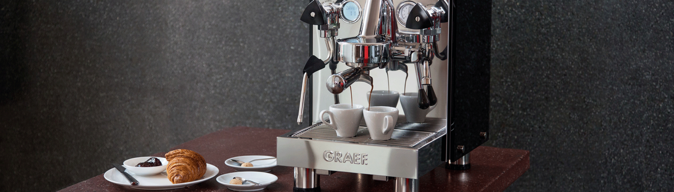 Macchina da caffè con croissant e pasticcini su un tavolo