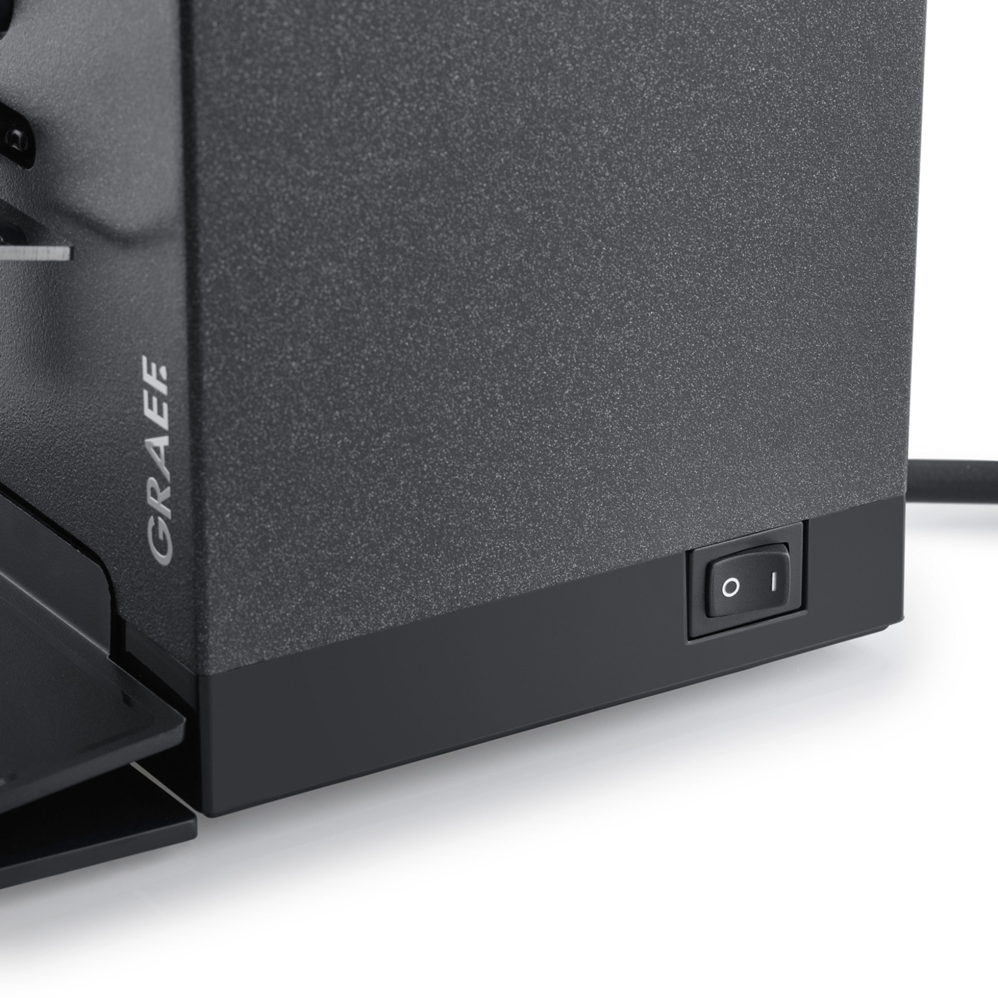 Graef device with on/off switch. Black casing, texture, detail shot, close-up.