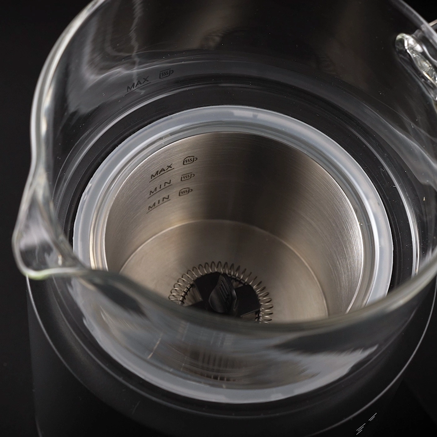 Gros plan d'un récipient en verre avec des marques de mesure maximales et minimales.