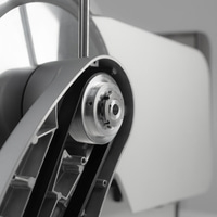 Primo piano di un dispositivo meccanico con cinghie e ingranaggi, in scala di grigi