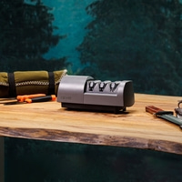 A three-stage knife sharpener and a knife on a wooden table.