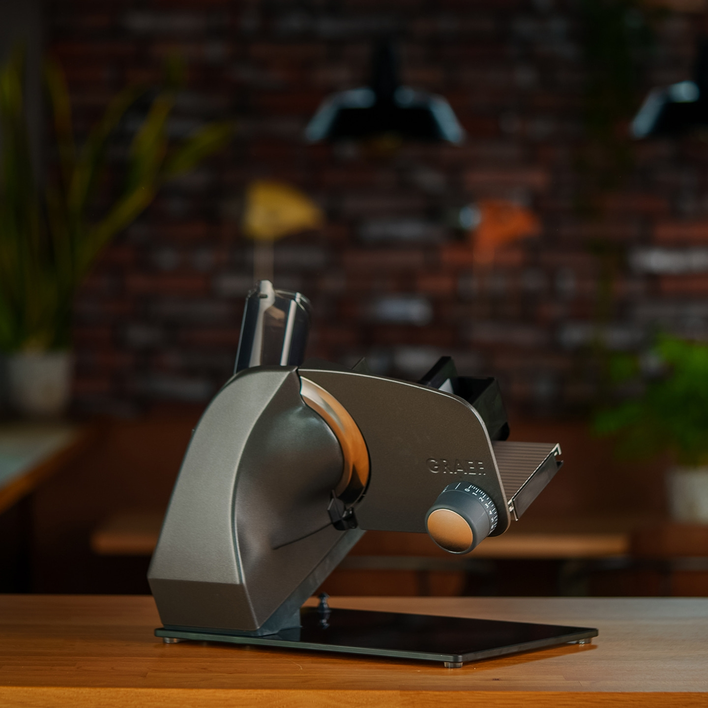 Trancheuse Graef sur table en bois, cuisine en arrière-plan