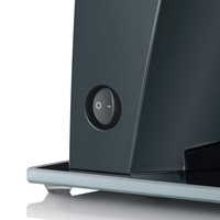 Primo piano di un elettrodomestico nero con interruttore on-off su piastra di vetro, isolato