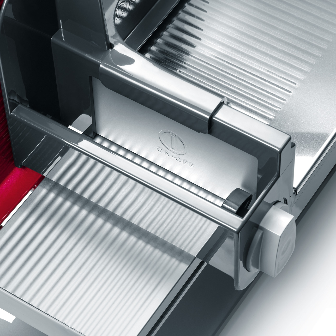 Gros plan d'une trancheuse à viande argentée avec interrupteur marche/arrêt.