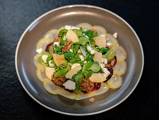 Salade avec poire, noix, fromage et légumes verts dans une assiette
