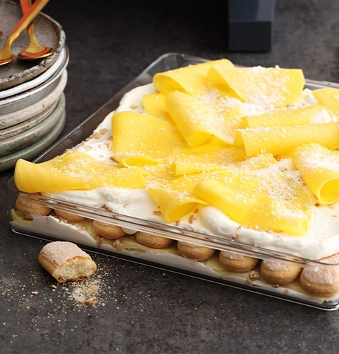 Dessert à la mangue, crème et biscuits à la cuillère dans un plat en verre