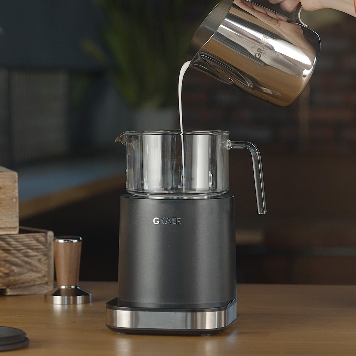 Du lait est versé dans un récipient en verre sur une machine Graef.