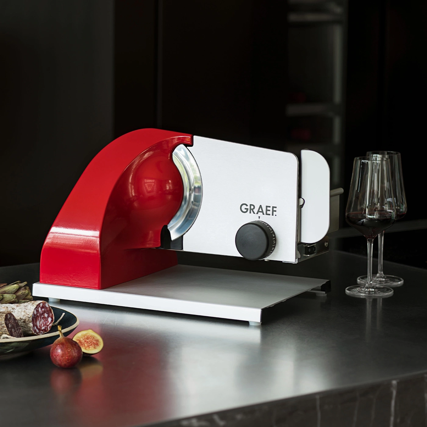 Une trancheuse Graef rouge avec saucisson et figues
