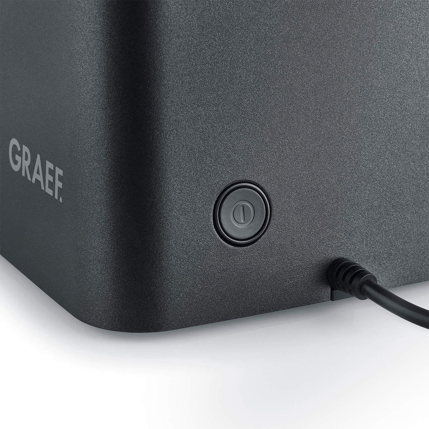 Gros plan d'un appareil Graef avec bouton et câble sur fond blanc