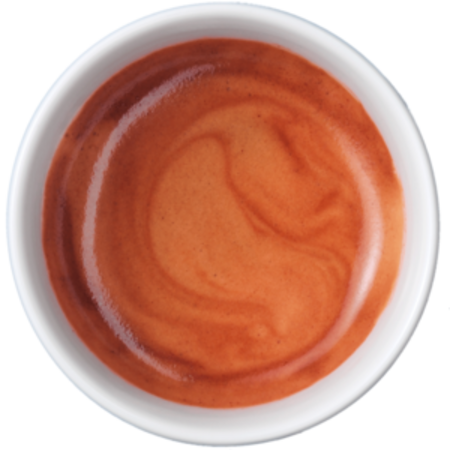 Primo piano di espresso in tazza bianca con consistenza cremosa