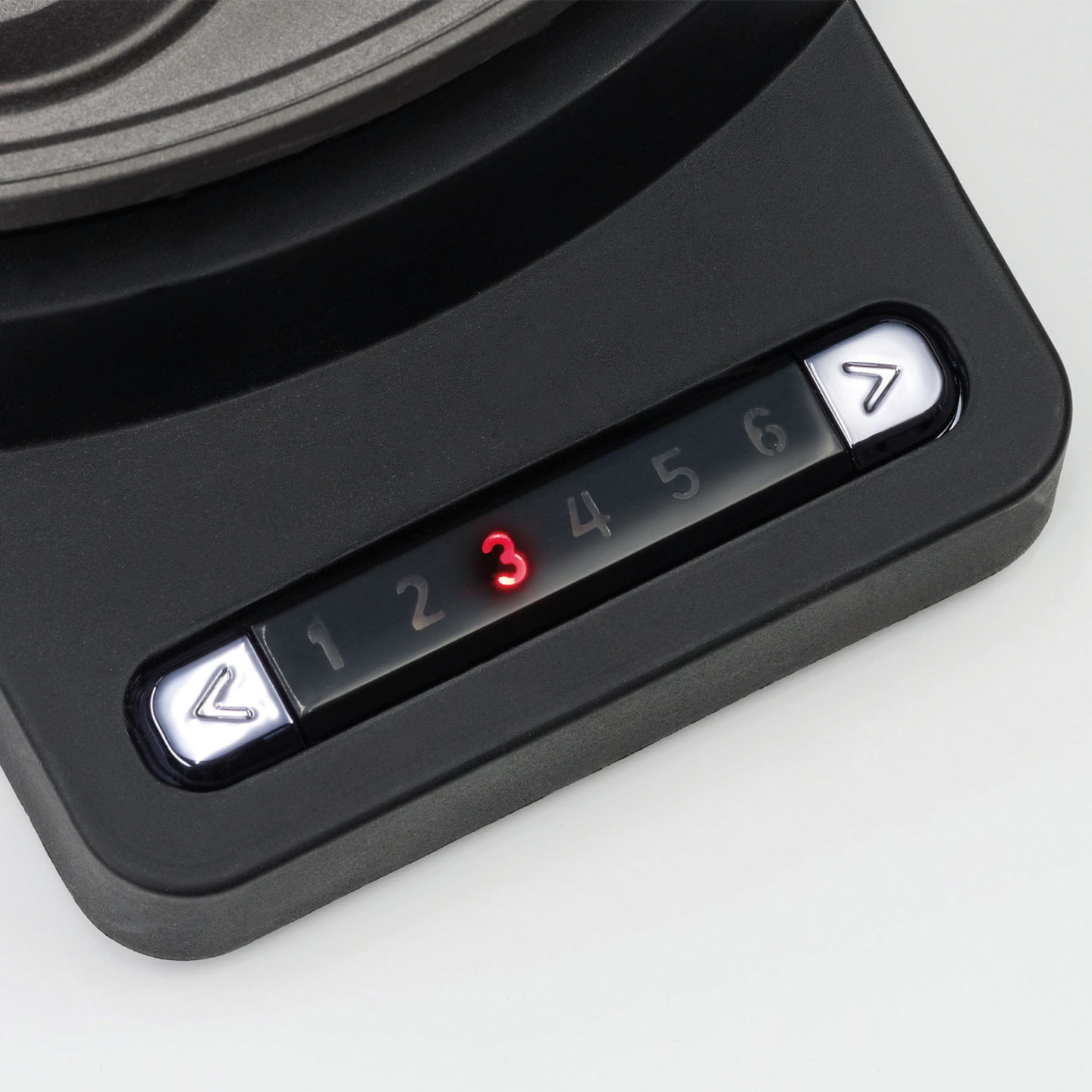 Appareil noir avec des lumières rouges et des chiffres de 1 à 6. Boutons fléchés.