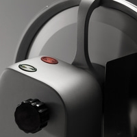 Primo piano di un dispositivo argentato con pulsanti e maniglia